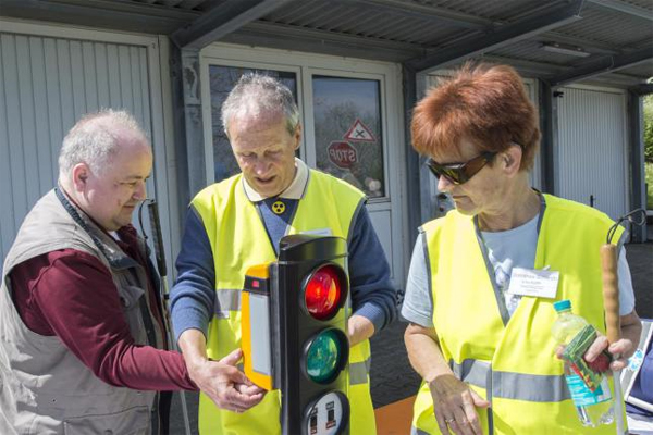 Blinde mit Instruktor vor dem Modell einer Ampel