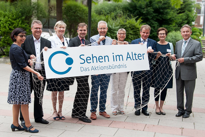 Vertreter des Aktionsbündnis "Sehen im Alter" mit einem Werbebanner